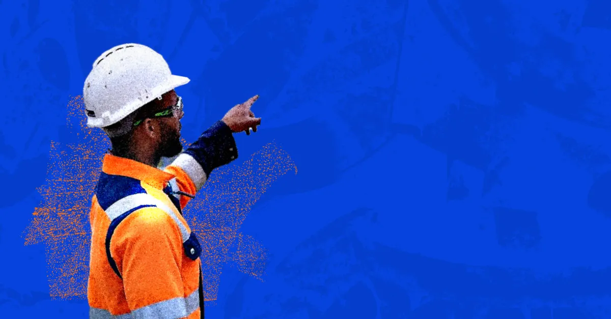 A person in a hard hat and safety vest pointing at a blue background.