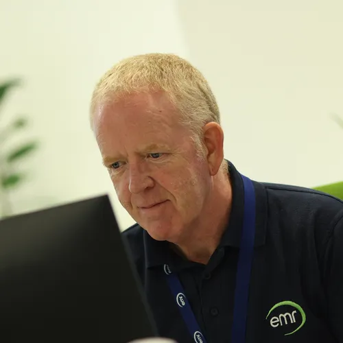 Person smiling and looking at computer monitor.