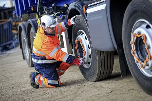 Driver checking wheels on truck