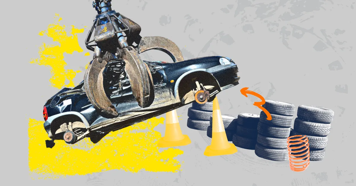 A black car being lifted by a crane above traffic cones and tyres.
