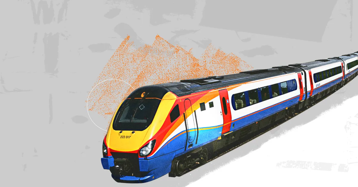A multi-coloured train on a track with orange splashes in the background.